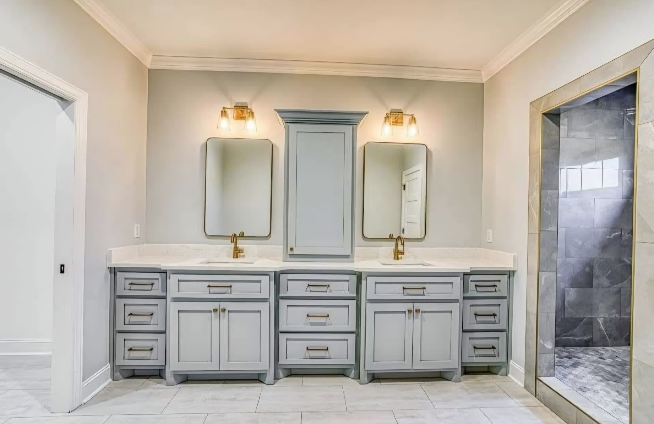 Bathroom vanity with marble countertop and tile shower